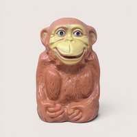 A large, light-brown molded plastic monkey bank with a tan face and a wide grin, standing against a neutral background.