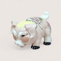 A vintage Kay Finch California pottery pig figurine with a pink floral pattern on its back and a humorous grumpy facial expression.