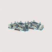A pair of Department 56 Heritage Village ceramic bridges featuring grey and cream railings with miniature lion statues at the entrance on a snowy base.