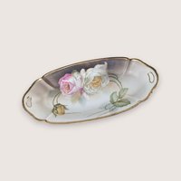 Antique porcelain celery dish from Suhl Germany featuring hand-painted roses and a gold-trimmed rim with handles.