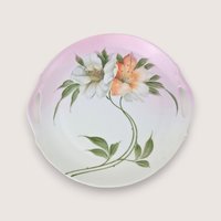 Antique Bavarian porcelain handled cake plate with hand painted orange and white flowers on a pink blush gradient background.