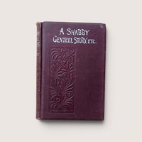 An antique burgundy book titled "A Shabby Genteel Story, Etc." with an embossed floral pattern on a beige background.