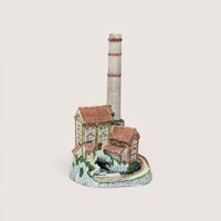 A miniature Lilliput Lane style factory figurine with a tall brick smokestack, centered on a beige background.