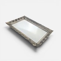 Vintage rectangular silver metal filigree vanity tray with a reflective mirrored surface on a white background.