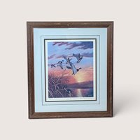 Framed and matted limited edition wildlife print of mallard ducks flying over a marsh at sunset.