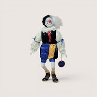 Vintage Royal Heirloom Collection clown doll with a painted ceramic face, velvet vest, and blue and yellow satin pants.
