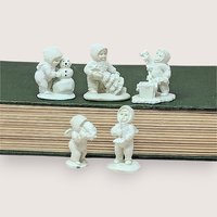 Collection of five white metal miniature Department 56 Snowbabies figurines shown in a row.