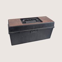 A vintage black plastic Service 8-track carrying case filled with a collection of retro music cartridges.