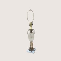 A vintage Hollywood Regency table lamp with a cut glass urn body and hanging crystal glass prisms.