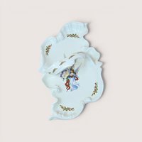 White ceramic divided serving dish with an integrated center handle, featuring an illustration of an angel holding a book surrounded by holly leaf accents, centered on a plain linen background.