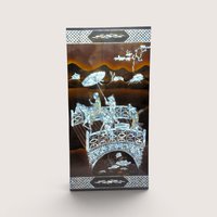 A large rectangular black lacquer wall panel featuring a detailed mother of pearl inlay scene with figures on a bridge.