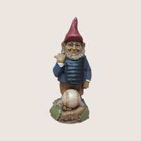 Vintage Tom Clark signed Ump baseball umpire gnome figurine standing behind a baseball on a linen background