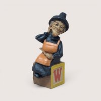1994 Tom Clark signed Wanda witch figurine sitting on a yellow alphabet letter W toy block on a linen background