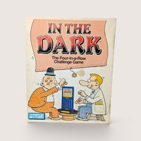 A vintage 1989 In The Dark board game box by Parker Brothers featuring a cartoon of two men playing with marbles.