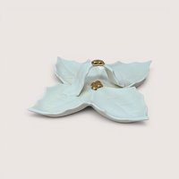 Vintage white ceramic divided serving dish shaped like a four-lobed holly leaf cluster, featuring a central looped leaf handle accented with gold-gilt berries at the top and base, centered on a plain linen background.