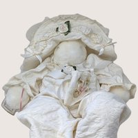 A large vintage 1994 Bunnies By the Bay artisan plush bunny doll named Evangeline wearing an ivory quilted romper and bonnet.