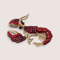 Vintage gold tone lobster brooch detailed with shimmering red rhinestones, dark red enamel, and black eyes.