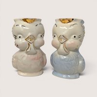 Vintage 1940s Shawnee Pottery ceramic owl creamer pitchers in pastel pink and blue with gold trim accents.