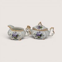 Vintage Napco porcelain creamer and lidded sugar bowl set with purple violet flowers and gold handles and trim.