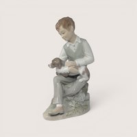 Vintage Zaphir porcelain figurine of a young boy sitting and petting a spotted puppy.