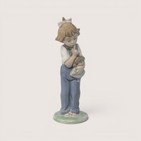Vintage Nao by Lladro glossy porcelain figurine of a young girl in blue overalls hushing the doll in her arms.