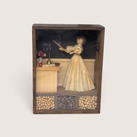 Vintage wooden shadow box diorama featuring a corn husk doll teacher, a blackboard, and compartments filled with dried beans.