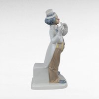 Vintage Porcelain clown figurine holding a flute.