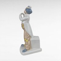 Vintage Porcelain clown figurine holding a flute.