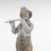 Vintage Porcelain clown figurine holding a flute.