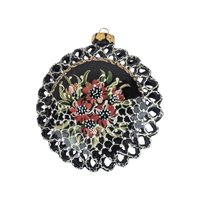A 4-inch round black clay ornament with a delicate reticulated or pierced lattice edge, featuring hand-painted red and white flowers with green leaves.