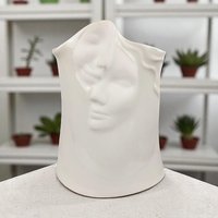 A minimalist, all-white porcelain vase sculpted in the shape of a serene female face. The vase features an elongated neck and a stylized head, with flowing hair textured into the ceramic. The entire piece is finished in a clean, high-gloss white glaze, emphasizing the smooth contours and delicate facial features without the use of color.