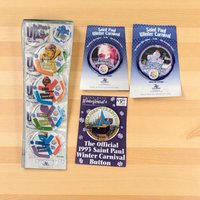 A diverse collection of vintage St. Paul Winter Carnival pinback buttons. Features colorful graphics, various sizes, and themes including Vulcan Rex, Boreas Rex, and years ranging from the 1960s to 1980s. High-gloss finish on round metal silhouettes.