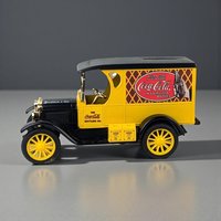 A die-cast metal bank in the shape of a vintage yellow and black Coca-Cola delivery truck. The vehicle features yellow spoked wheels, gold-toned hardware, and detailed side graphics including a red Coca-Cola logo and a "8 million a day" slogan on the hood.