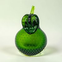 A heavy emerald green glass pear with a clear stem and leaf. The interior is filled with a uniform pattern of tiny air bubbles. It has a flat base and a secondary flat side for angled display.