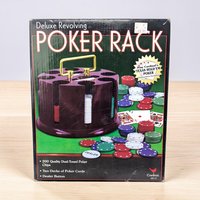 A circular black plastic rotating poker rack holding colorful chips. The texture is smooth and glossy with a central carrying handle and a cylindrical silhouette.