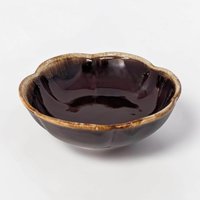 A shallow, round ceramic bowl with a rich dark chocolate brown glaze. A thick, frothy cream-colored drip effect rings the smooth top edge, flowing downward toward the center in an organic pattern.