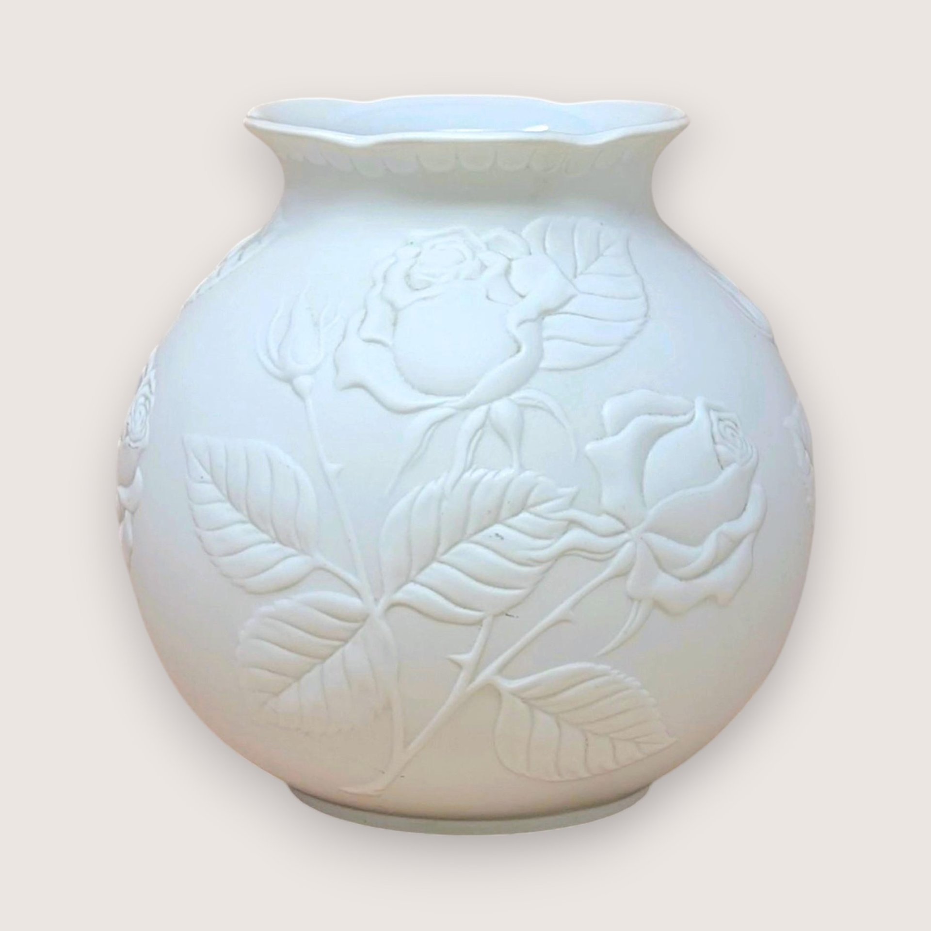 Kaiser West Germany white bisque porcelain vase with a globular body and flared rim. Features a high-relief embossed rose and leaf design with a soft matte finish. 5.5 inches tall.