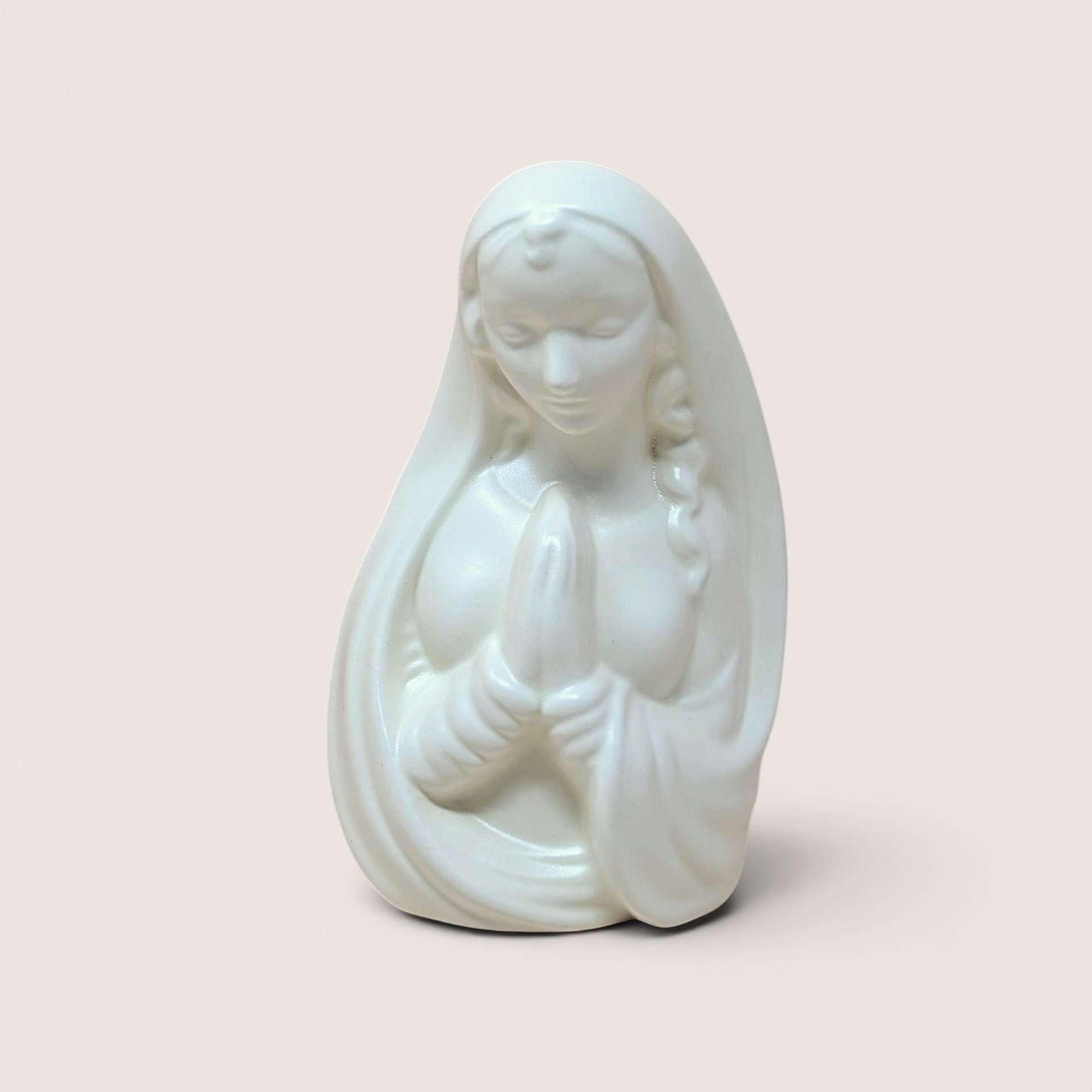 Mid-century white ceramic planter featuring a bust of a praying Madonna. Smooth, semi-matte ivory finish, flowing drapery, and serene facial expression. Hollow back for plants or stems.