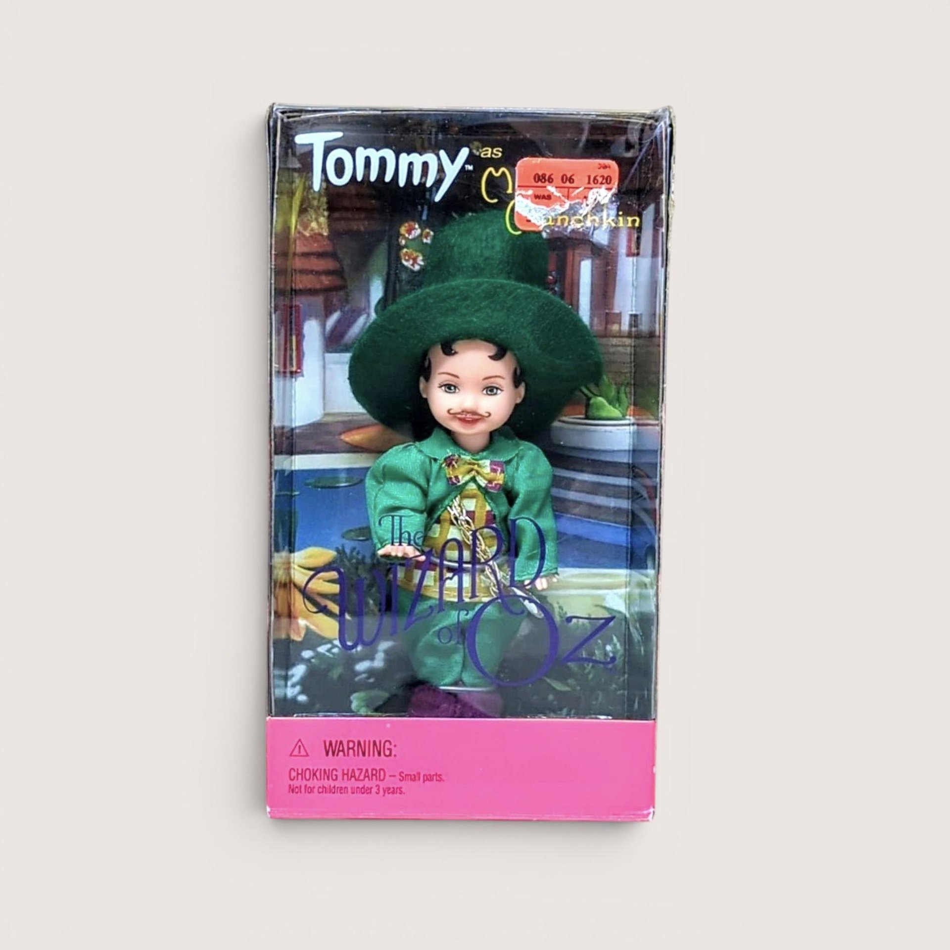 A 4.5-inch Tommy doll dressed as the Mayor Munchkin in a green jacket and hat, displayed inside its original 1999 Wizard of Oz themed window box.