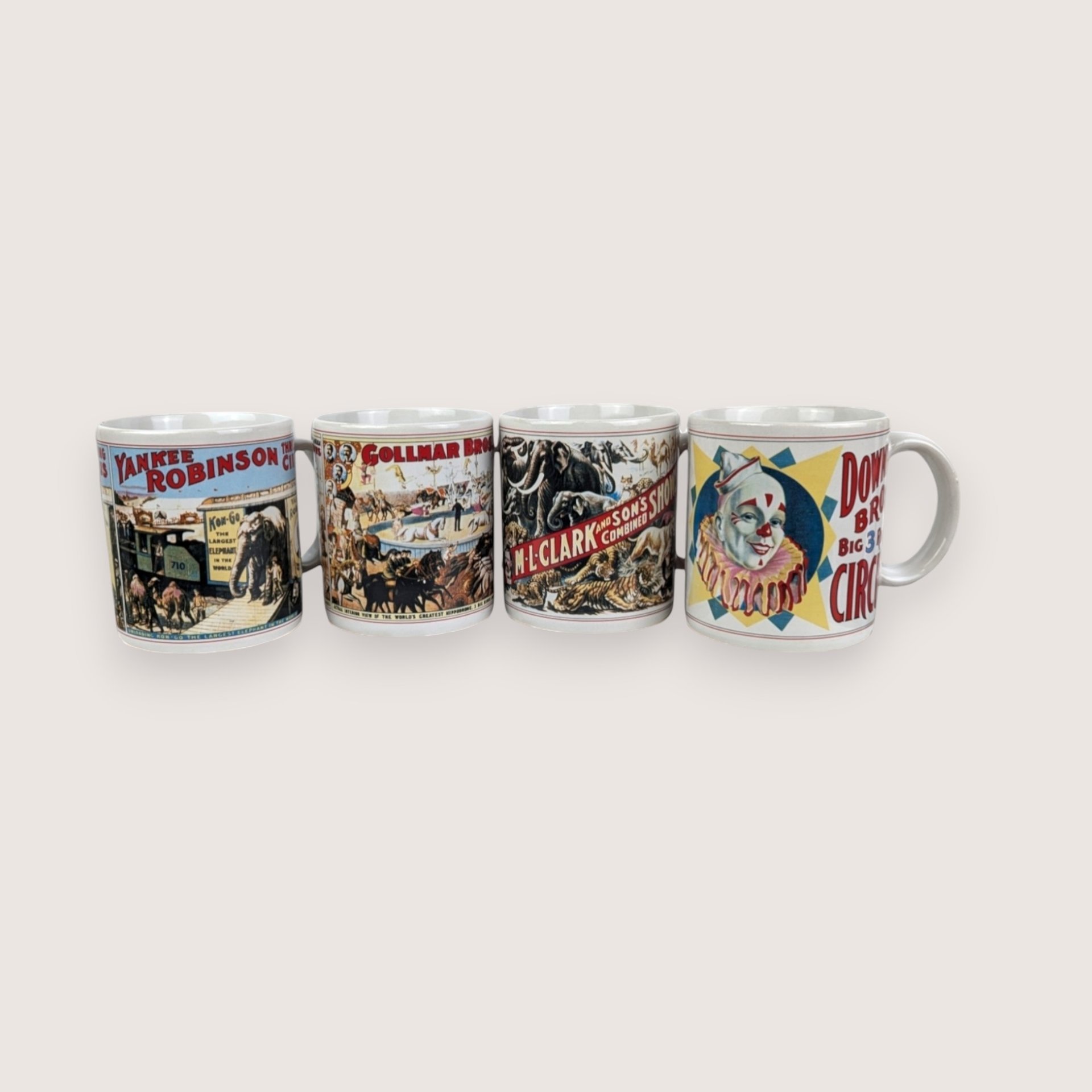Set of four white ceramic mini mugs featuring colorful vintage circus poster illustrations lined up in a row.