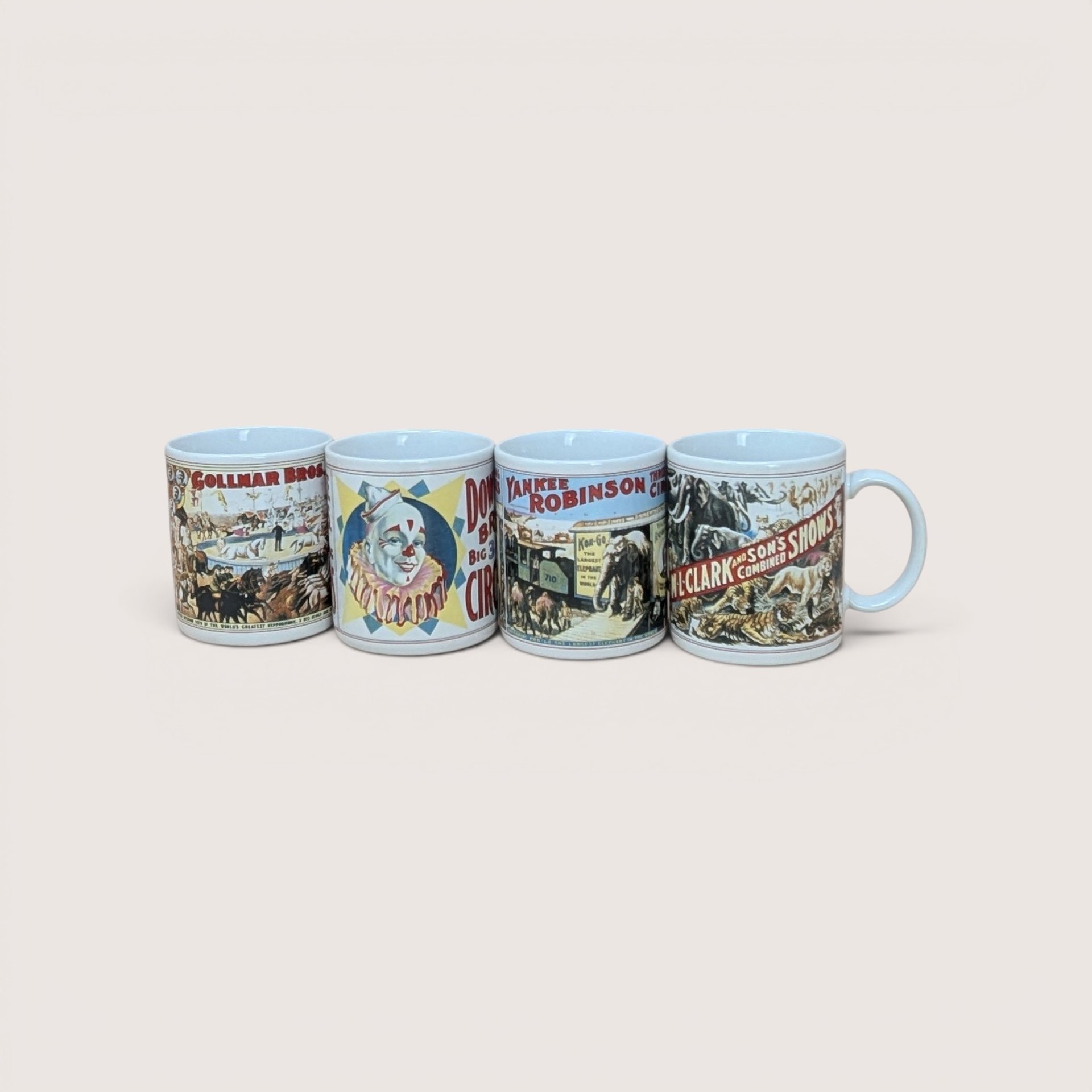 A yellow vintage box containing a set of four white ceramic mugs, each featuring a different colorful vintage circus poster illustration.