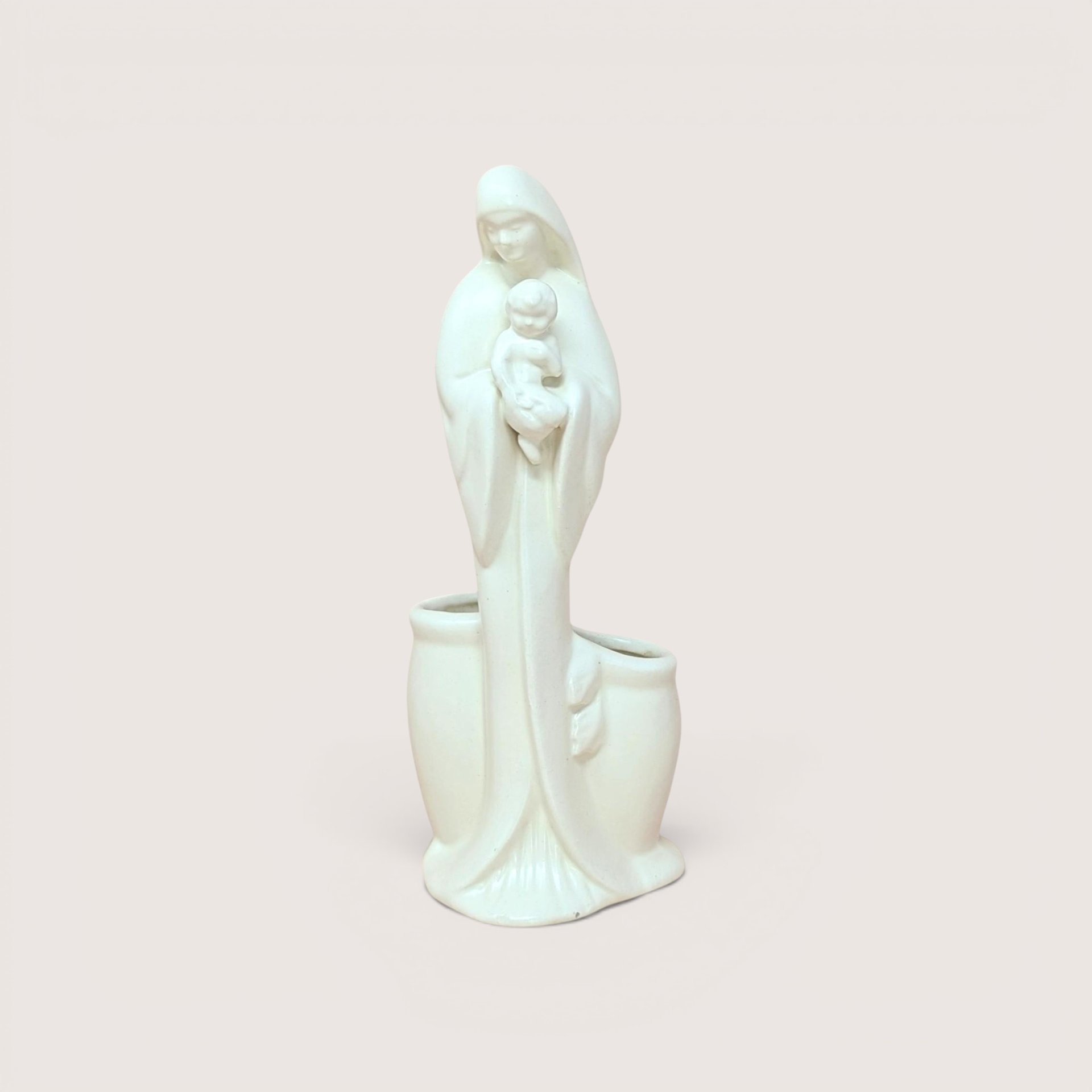 A white ceramic Madonna and Child planter figurine, centered on a beige background.