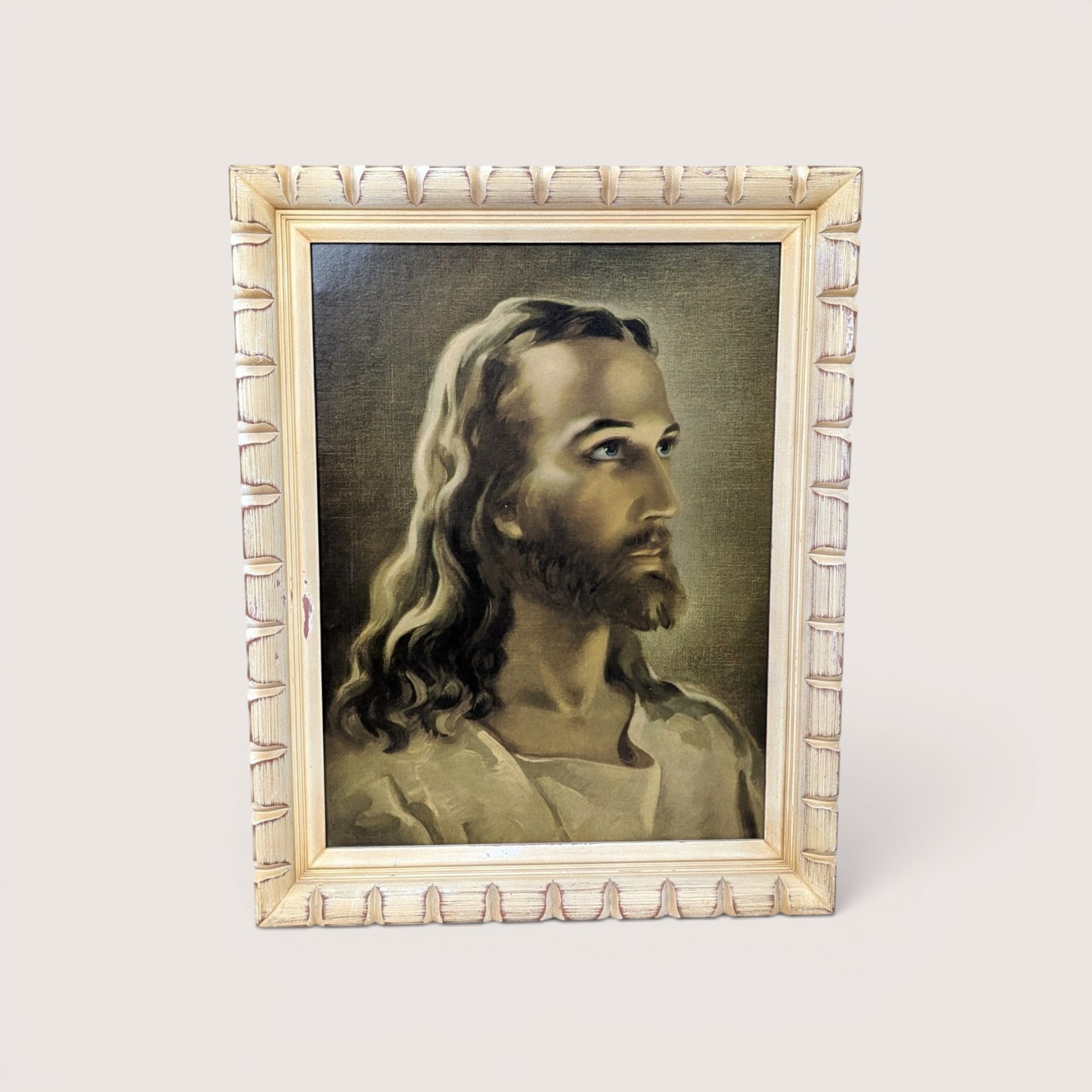 A framed vintage portrait print of Jesus Christ in profile looking upward, centered on a beige background.