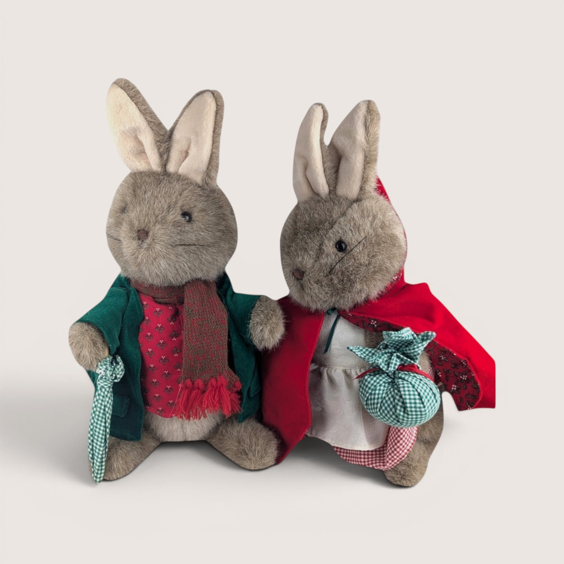 Two vintage Eden Toys Peter Rabbit and Mrs. Rabbit plush bunnies dressed in detailed fabric outfits side by side.