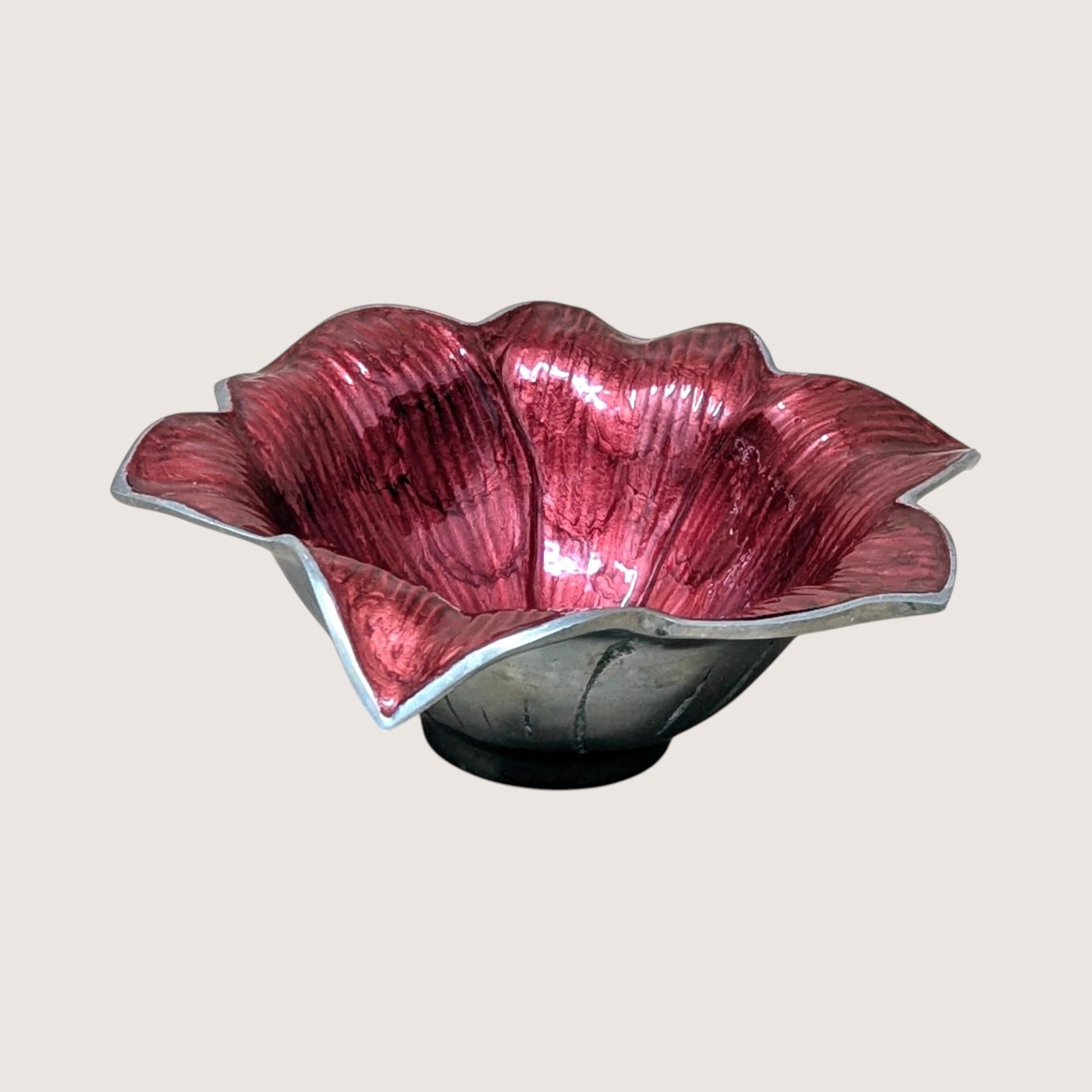A sand-cast aluminum lily flower bowl with a glossy, jewel-toned raspberry pink enamel interior on a plain background.