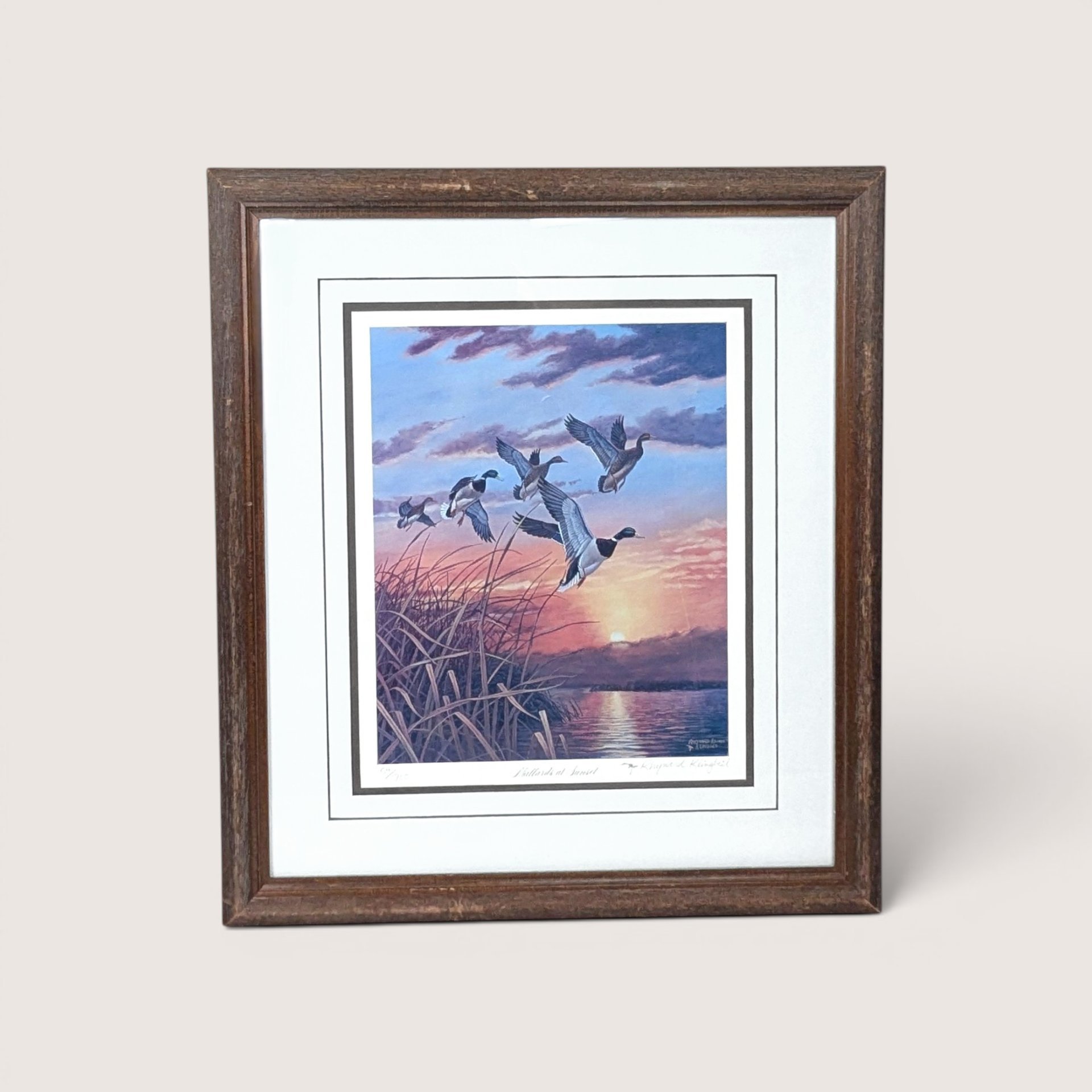 Vintage framed and matted Rhynard Klingbeil wildlife print titled Mallards at Sunset showing ducks flying over a marsh.