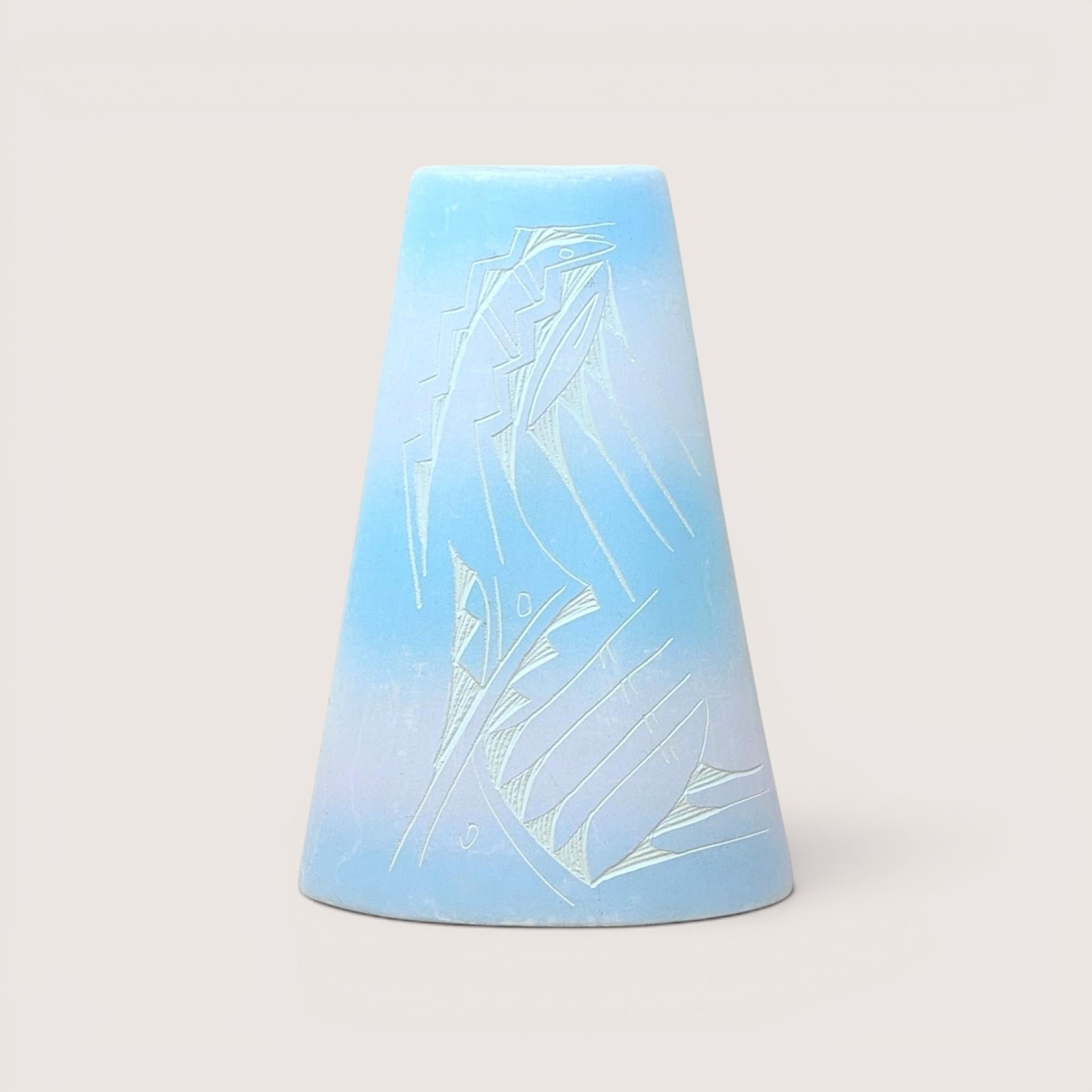 A conical light blue ceramic vase with an etched abstract geometric design, centered on a beige background.