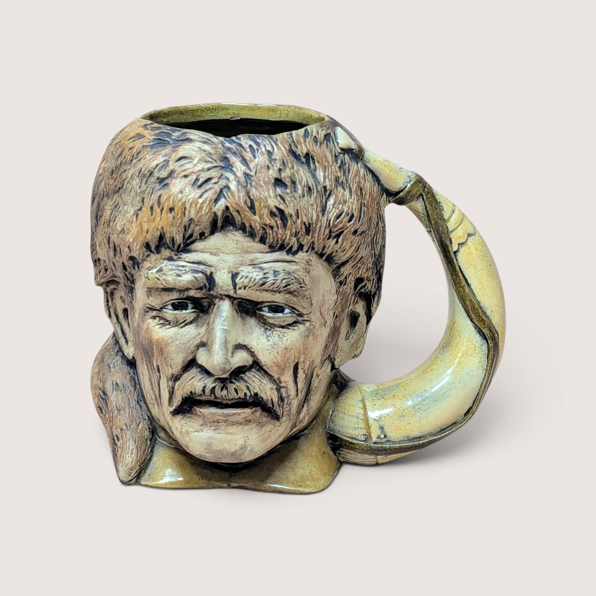 A vintage hand-painted ceramic character mug shaped like Davy Crockett wearing a coonskin cap with a powder horn handle.