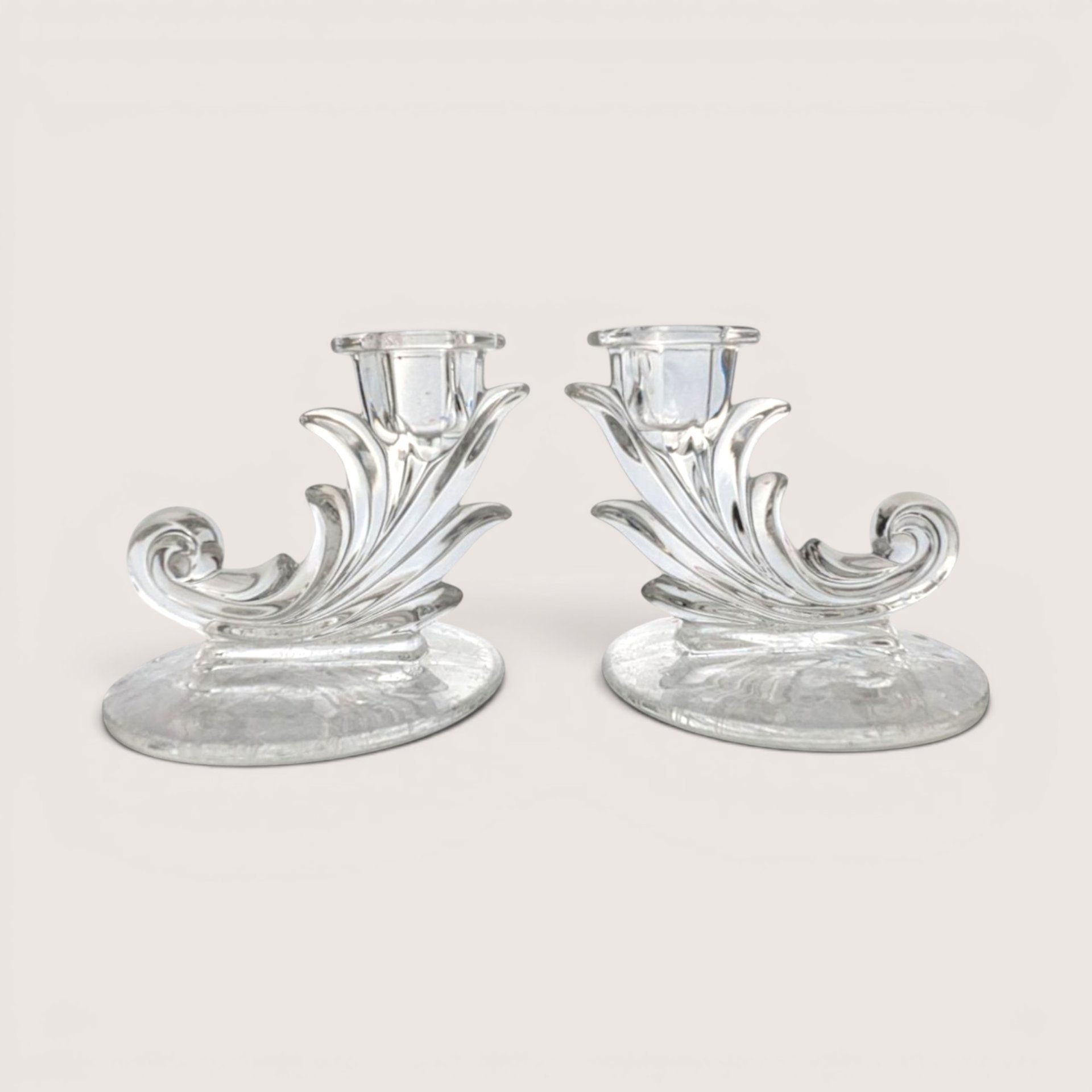 Pair of vintage Fostoria clear glass cornucopia scroll candlestick holders with delicate floral etching on the bases.