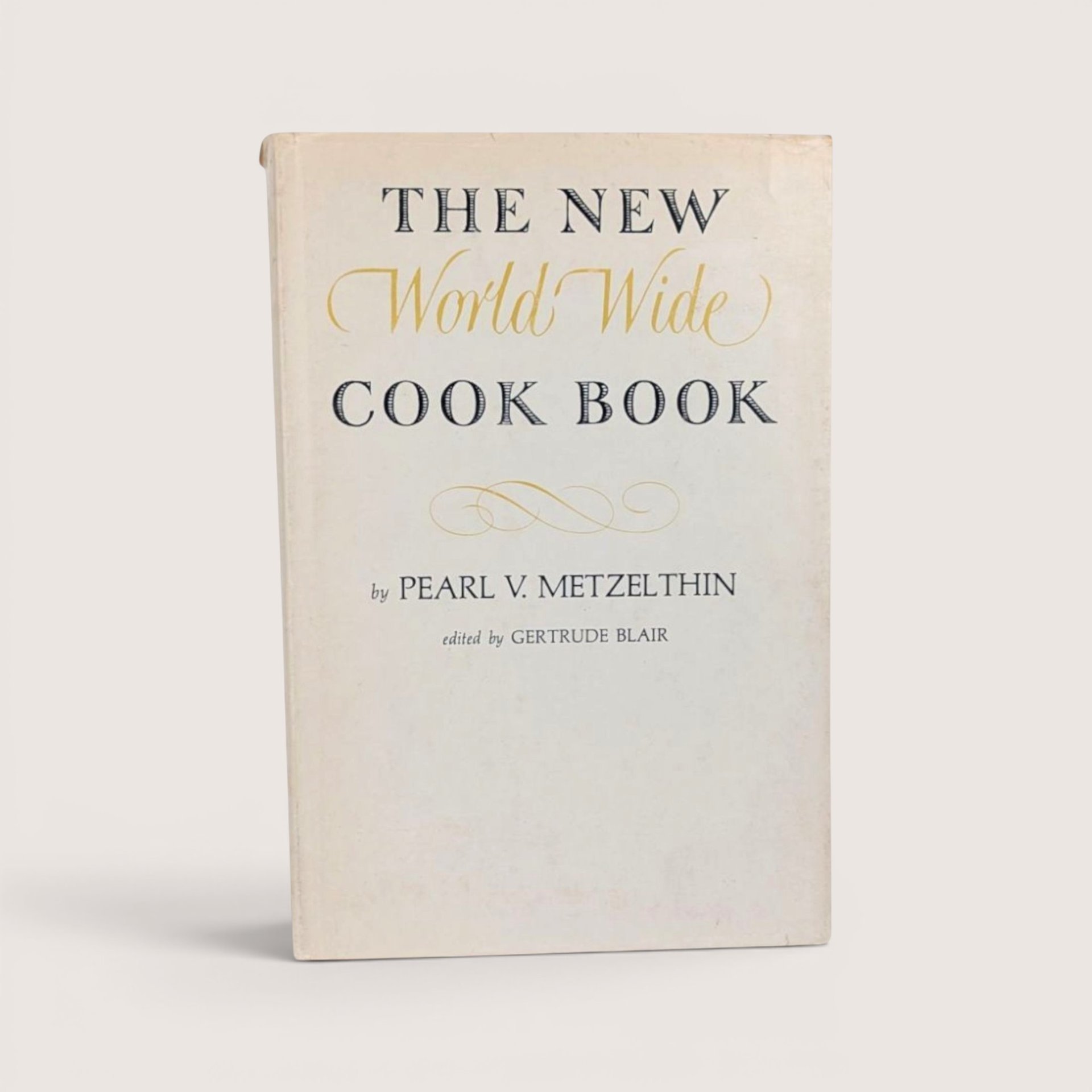 The New World Wide Cook Book 1939 vintage hardcover by Pearl V. Metzelthin with gold and black typography.